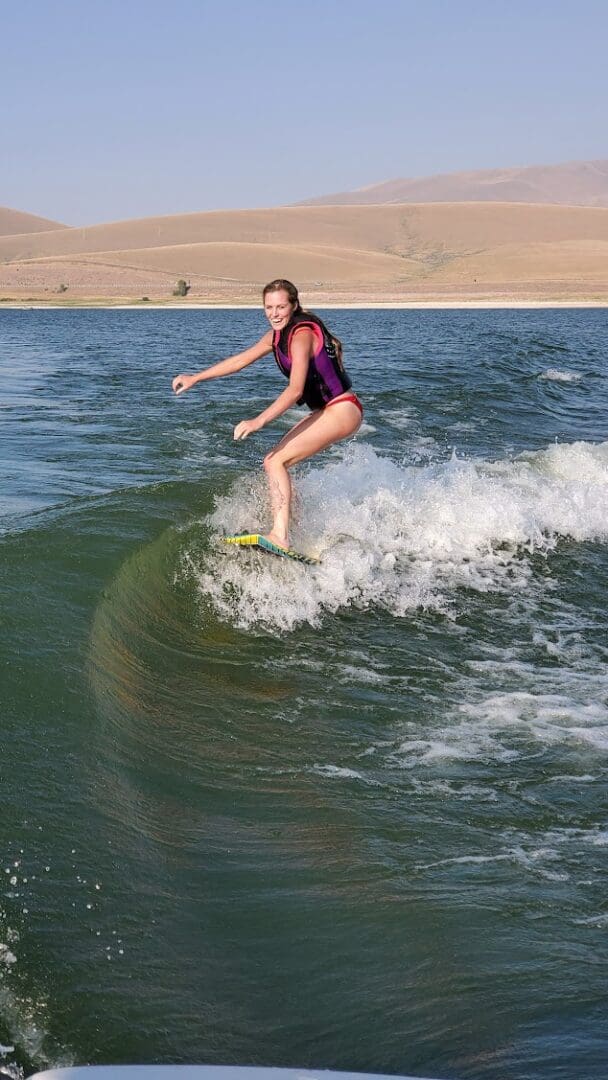 A woman is surfing on the water