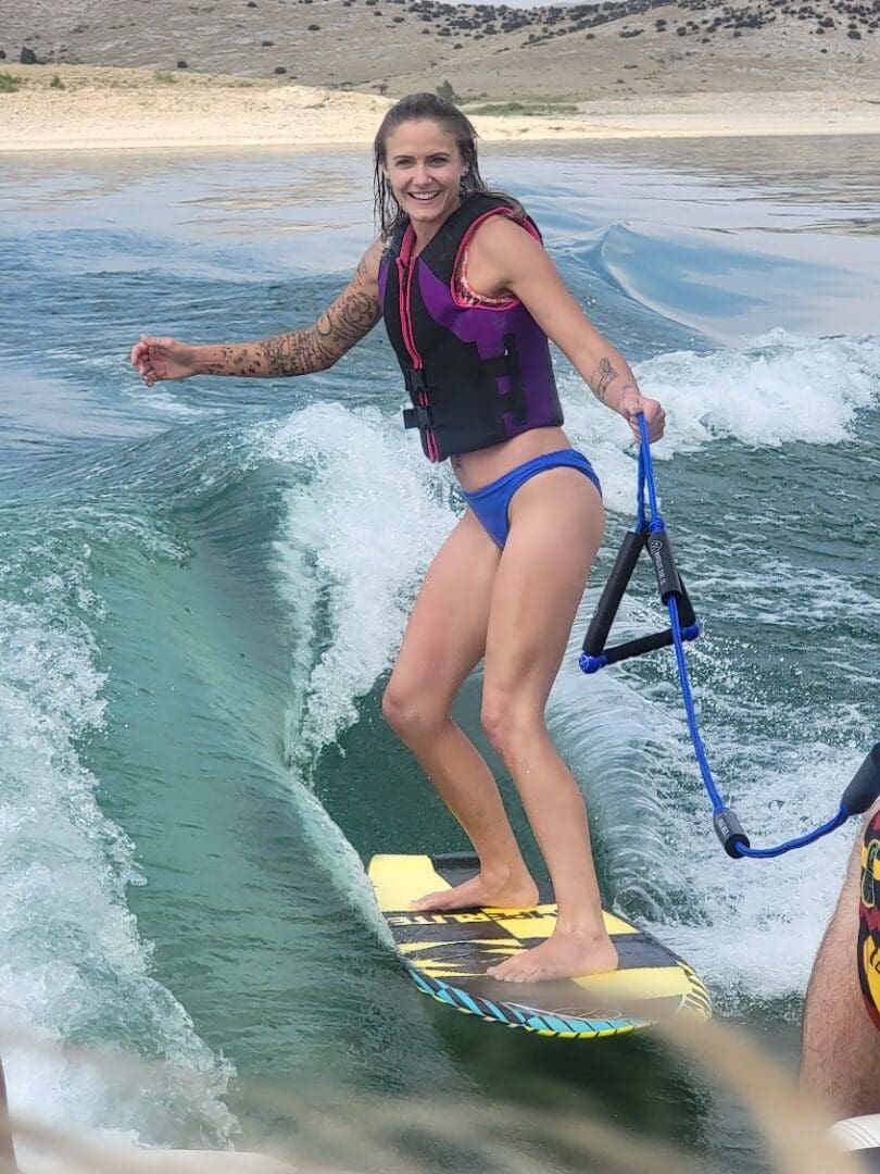 A woman is riding the waves on her surfboard.